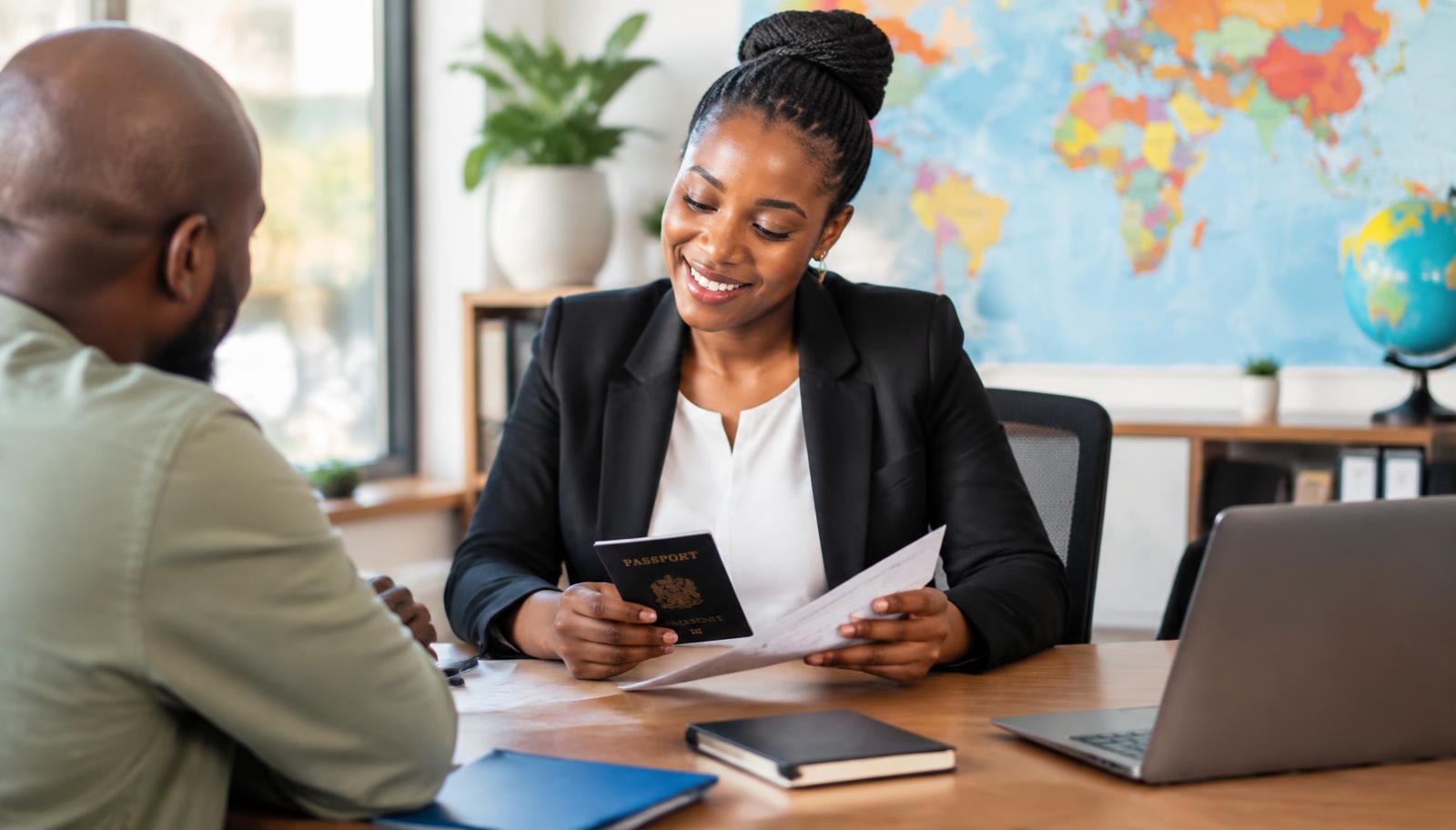 Harmaz Travel visa consultant reviewing a passport and documents with a client in Addis Ababa